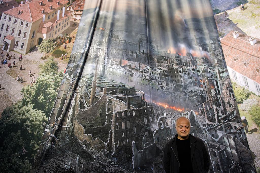 Artist Yadegar Asisi with a test print of the panorama "Dresden 1945 – Tragedy and Hope of a European City," which depicts Dresden, Germany, after the city was bombed in Feb. 1945. The installation is from the perspective of the town hall tower. The panorama goes on display at the city's Panometer on Jan. 24.