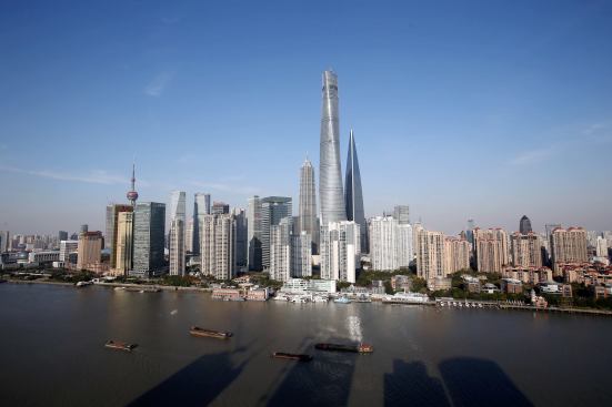 The skyline of the Lujiazui Financial District showing the Shanghai Tower, the tallest skyscraper in the middle, added. The tower is now under construction next to the Shanghai World Financial Center, right, as well as the Jinmao Tower and other skyscrapers and high-rise buildings in Shanghai. Construction is scheduled to finish in December, when the last tower crane is torn down and an eddy current damper is installed. Estimated to start official operation in mid-2015, the tower will carry out equipment testing and closeout decoration in the coming months.