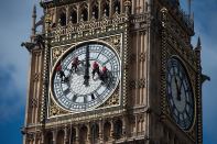 Workers clean the face of the Big Ben clock in London.