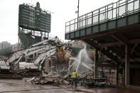 Construction crews begin to demolish the outfield walls at Wrigley Field in Chicago for the ballpark's $575 million renovation project.