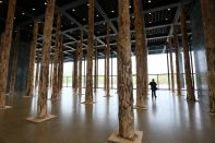 David Chipperfield's "Sticks and Stones" installation at the Neue Nationalgalerie in Berlin consists of 144 tree trunks. The British architect is on deck to renovate the gallery, originally designed by Ludwig Mies van der Rohe, next year.