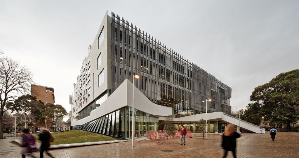 The new architecture school building fronts a quad at the University of Melbourne; a façade clad in Bianco Precast concrete panels overlooks an adjacent greenspace.