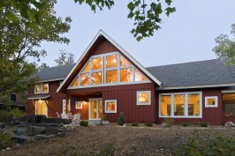 Back exterior of red A-frame cabin in the woods