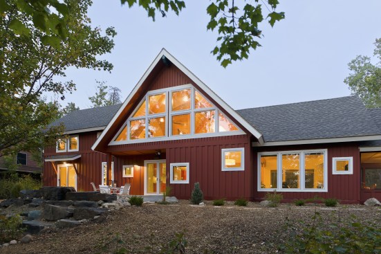 Back exterior of red A-frame cabin in the woods