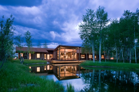 Exterior, horizontal, overall rear elevation at twilight with pond, Kahlbetzer residence, Wilson, Wyoming; Ward + Blake Architects