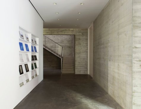White walls for mounting artwork contrast with the stark concrete floors and walls.