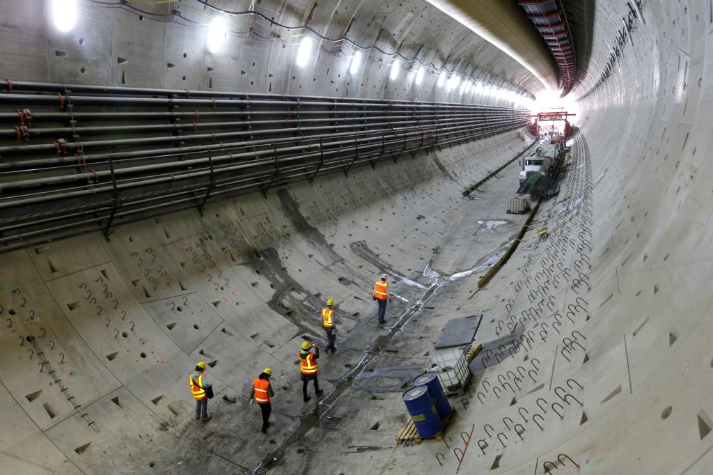 Visitors walk through a five-story tunnel being constructed to replace the Alaskan Way Viaduct in Seattle. Progress on the two-mile tunnel that will move State Route 99 underground stalled in December after the tunnel boring machine had to be shut down for repairs, but work on tunnel walls and other structures continued. The tunnel topped a list of "11 highway boondoggles" that shouldn't be constructed, in a report released yesterday by the U.S. Public Interest Research Group Education Fund. [The Seattle Times]