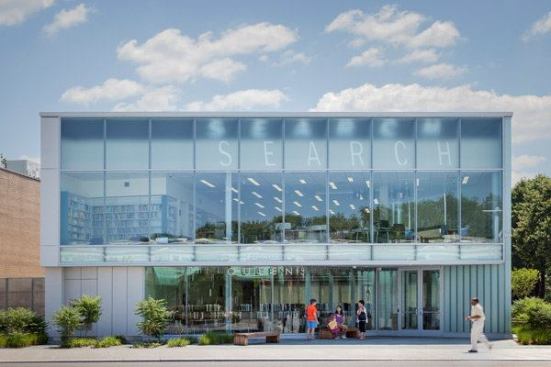 On a sunny day at the Glen Oaks branch library in New York, passersby can watch the word “search” emerge from the upper right corner of the parapet, enlarge to full height at noon, and then steadily disappear into the upper left corner.