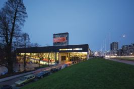 As viewed from the southeast, the Kunsthal is intersected by a service road and edged by a highway to the south.