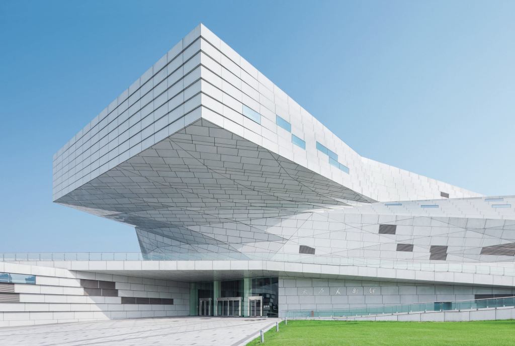 Emerging from the low-slung, knot-like form of the museum, a large prismatic cantilever on the south façade marks the entrance.