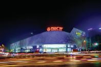 Opened in September 2013, this 860,000-square-foot luxury shopping plaza in Wuhan, China, features a façade illuminated with 3.1 million LEDs housed in 42,333 stainless steel spheres. The façade has no right angles, but rather wraps its way around the five-story building. Silver by day and pulsing with color at night, the fixtures cluster above entrances to steer wayfinding.
