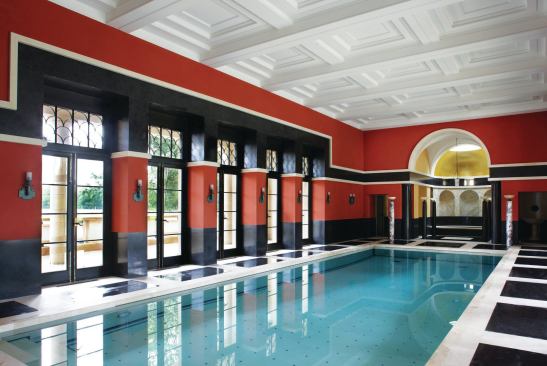 The marble floors continue into the pool hall, which is lined with Pompeian red walls. The hot tub in the apse is flanked by a sauna and a steam room.