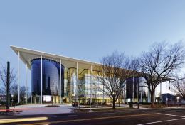 The main entrance to Edward P. Evans Hall is flanked by two curved volumes clad in blue glazing, which house stacked lecture halls on the upper levels.