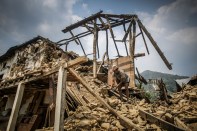 A Nepalese man cleans the rubbles of his destroyed house.