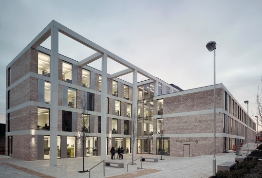 The building exterior is a mix of brick from Traditional Brick & Stone and glass-fiber-reinforced concrete from GB Architectural Cladding Products. Around the Technal windows, which incorporate Saint-Gobain glass, is a perforated screen from WPL.