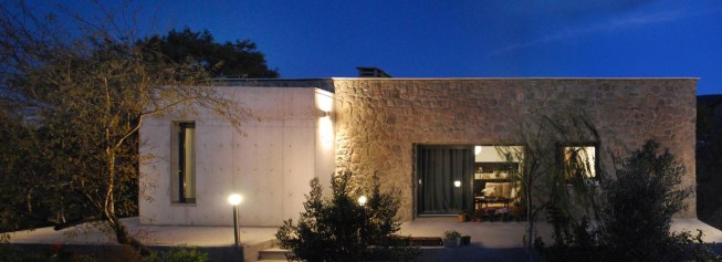 west facade with natural stone, exposed concrete and glass.