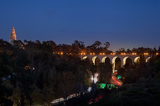 San Diego’s Cabrillo Bridge, which passes over state Route 163, serves as the main gateway to Balboa Park. The illuminated tower of the Museum of Man sits off in the distance.
