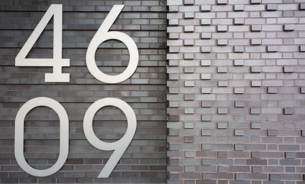 An address plaque on the façade of 46-09 Eleventh St, in Long Island City, N.Y.