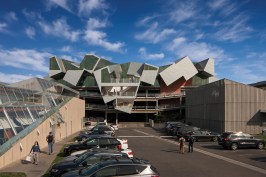 Pterodactyl's western facade overlooks a parking lot framed by four other Eric Owen Moss projects: The Umbrella (at right), Slash (at left) and Backslash, and Stealth. The new office and exterior stair projects out and over an existing parking garage.
