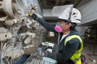 A preservationist reapplying an restored ornament on the exterior of the Capitol.