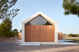 From the front, the Cottage in the Vineyard looks like a simple gabled structure, with a concrete frame that is as tall as it is wide.