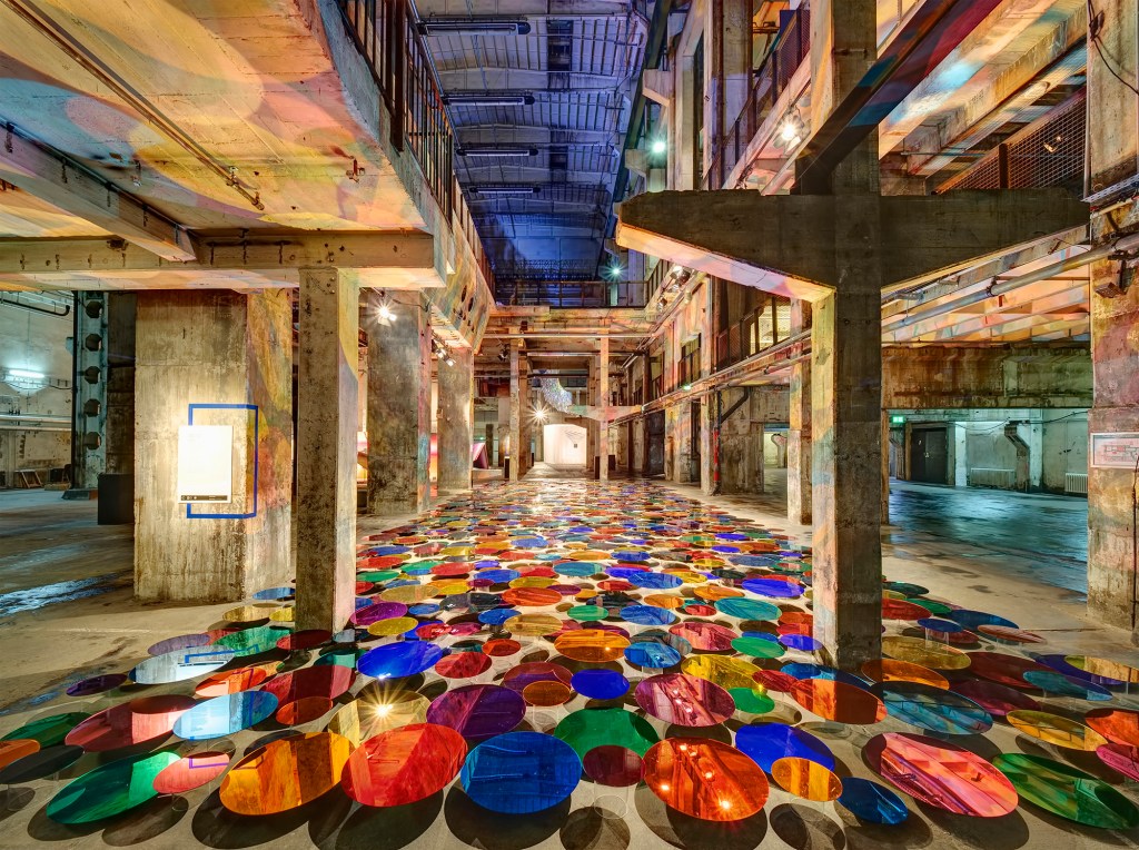 Liz West's latest work, “Our Colour Reflection,” explores the interplay between light, color, and reflection using colored acrylic mirrors in different sizes.