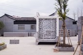 Located on the grounds of the WinSun architectural 3D printing facility in Suzhou, China, this 3D-printed concrete guardhouse prototype integrates furniture, shelving, seating, and even a bed.