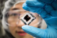Xiaozhou Che, EECS Graduate Research Assistant, holds an organic tandem photovoltaic cell