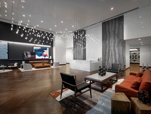 The design concept blends sleek urban elements with natural materials.  In the lobby, guests are drawn into the space by an undulating light fixture that cascades down to the white marble reception desk.