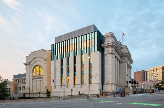 The Senate of Canada Building completes the previously blank elevation, reimagined as a modern interpretation of the building’s stone-columned, Beaux-Arts facade. 