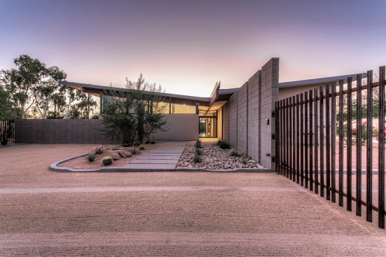 Front entry of home.  The low point of the butterfly roof is centered over the front entry door.  An 
exposed beam connects the roof and creates an organizing element inside and outside the home.  This 
exposed beam defines the interior circulation path of home. 