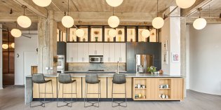 New kitchen with large island and custom steel & glass backlit upper shelves.