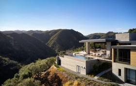 Situated on a promontory jutting into the canyon below, the hillside retreat boasts multiple vistas of the surrounding canyon and the Pacific Ocean beyond.