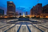 Looking west onto the entry plaza, curved up-lit wall, and St. Louis Court House, Gateway Arch Museum and Visitor Center