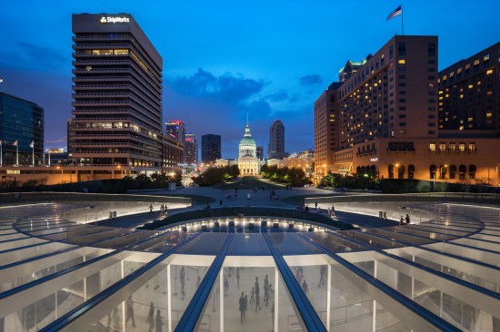 Looking west onto the entry plaza, curved up-lit wall, and St. Louis Court House, Gateway Arch Museum and Visitor Center