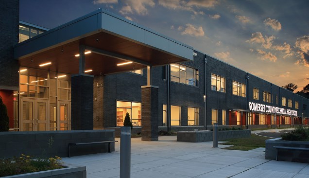 A large overhang welcomes students and guests to the facility. The composite wood soffit creates a warm inviting glow and is engineered to last for generations.