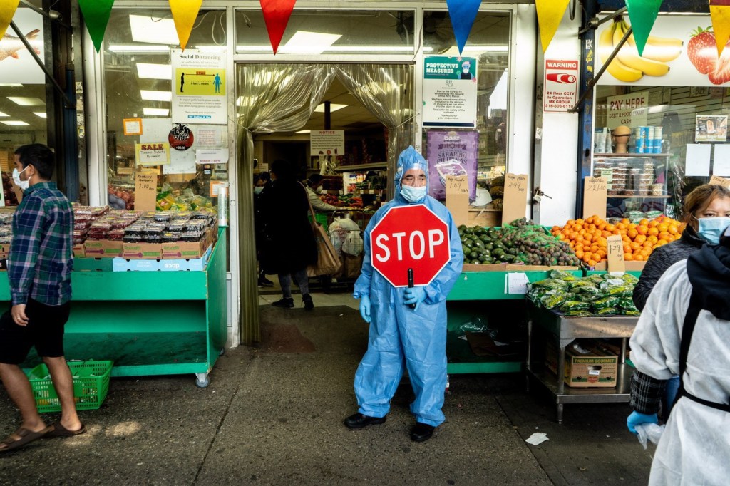 April 25, 2020: José, wearing protective gear and controlling entry to the H F Dollar & Up Fruits & Vegetables store, 61-27 Roosevelt Avenue, Queens, N.Y.