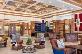 The Lobby of the Brownwood Hotel, in The Villages, FL, mixes rustic cowboy-inspired elements with an elegant coffered ceiling and crystal chandeliers.