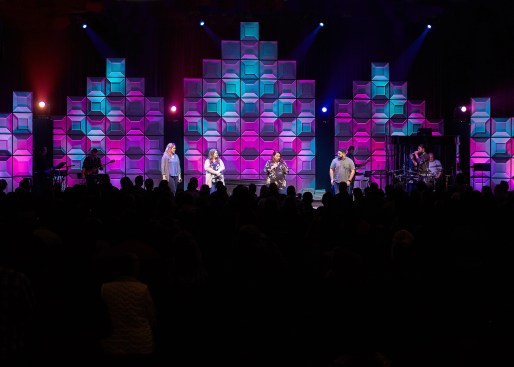 The stage design team at Blue Ridge Community Church created a versatile luminous wall using translucent ceiling panels that were illuminated from the rear. The top of each section was tapered to suggest the shape of cathedral arches. The wall, in the main sanctuary, was 18 feet tall at the center, yet very lightweight.