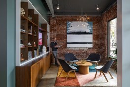 The lounge has guest seating and a curated library with books featuring California architects and designers on display. The room is also set-up for telework for visitors to AIACA.