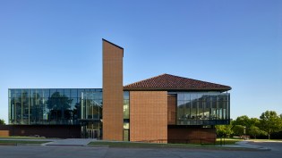 The north elevation illustrates the intersection of the dual facades as the traditional masonry and clay tile roof on the west begins to transition to zinc cladding and glass on the east.