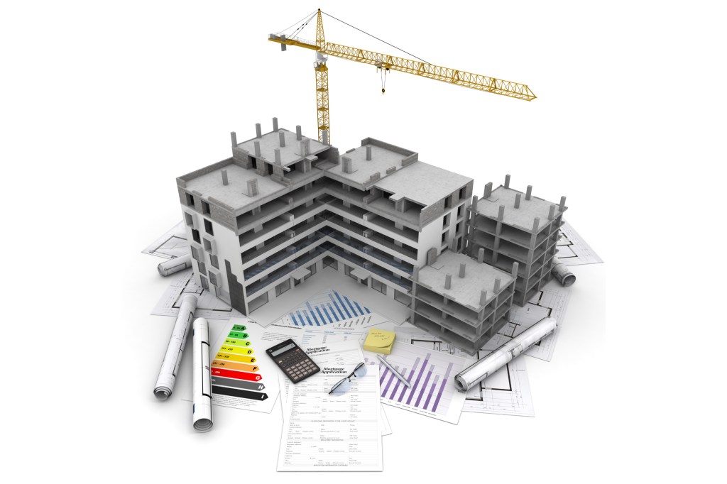 Building under construction with crane, on top of blueprints, mortgage applications and energy rating