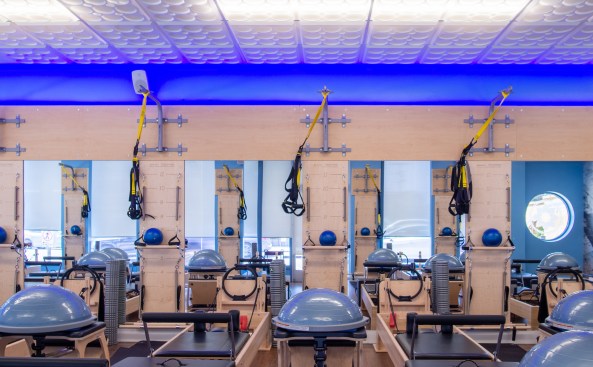 A chain of Club Pilates exercise studios in Southern California have created a signature décor built around a
Ceilume decorative thermoformed ceiling with a blue glow lighting up the edge.