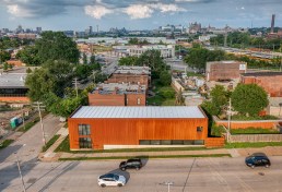 Due to the sloped street and the need for a continuously-flat first floor for ease of gallery work, the live-work studio submerges in the site, accentuated by a 50-foot long window set on the foundation and near the level of the sidewalk, doubling as clerestory diffused light for the workshop. The roof is comprised of Structurally Insulated Panels, with integral standing seam metal roofing painted white to reflect the intense summer sun.