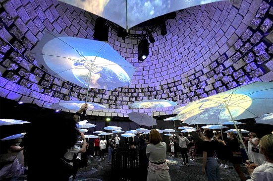 Visitors at the Netherlands Pavilion are showered with digital projections captured on translucent umbrellas.