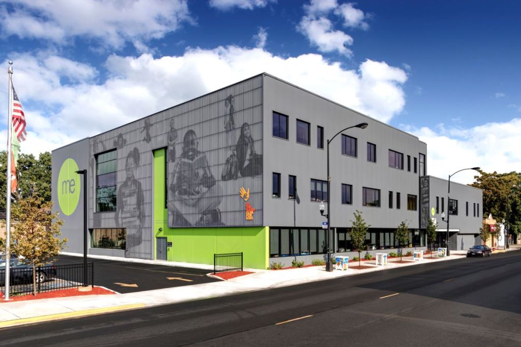 The local community is forefront in the façade of Moving Everest Charter School, where real students are featured in the screen-printed images beneath perforated corrugated metal panels.