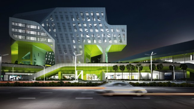 Transitions in façade wrapping, from diagonally-oriented punched windows to perforated rainscreen cladding over glazing, blend programmatic volumes for the mixed-use center.