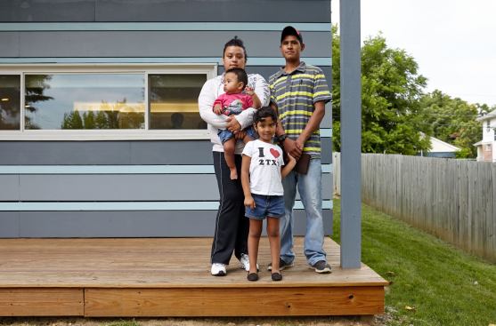 The owners of the Habitat for Humanity Prototype house stand on their new porch.