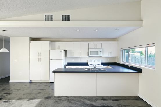 Inside, the house was designed to be both accessible and durable. The kitchen, which opens onto the living and dining area at the front of the house, features Formica countertops and Whirlpool appliances.