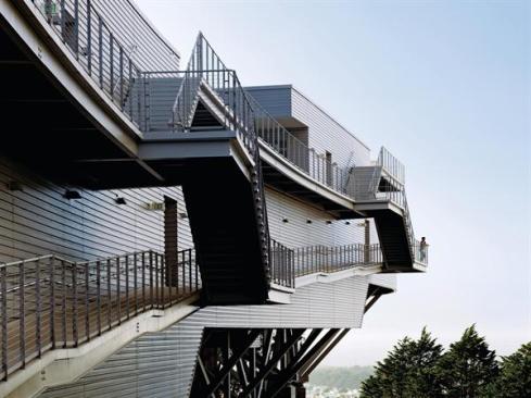Outdoor staircases hung off of the side of the building offer a direct circulation route between the stepped floor plates and green roofs.